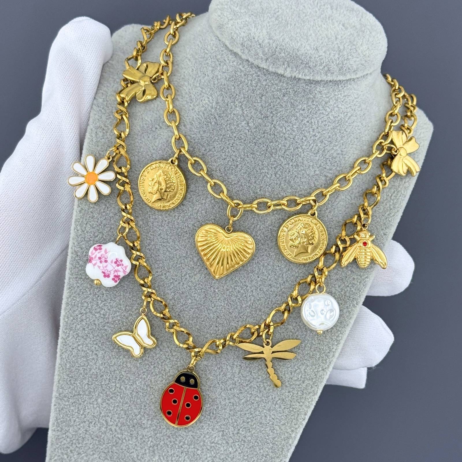 Layered Gold charm necklace featuring a heart pendant, bow accents, and vintage coin charms crafted from waterproof hypoallergenic stainless steel.