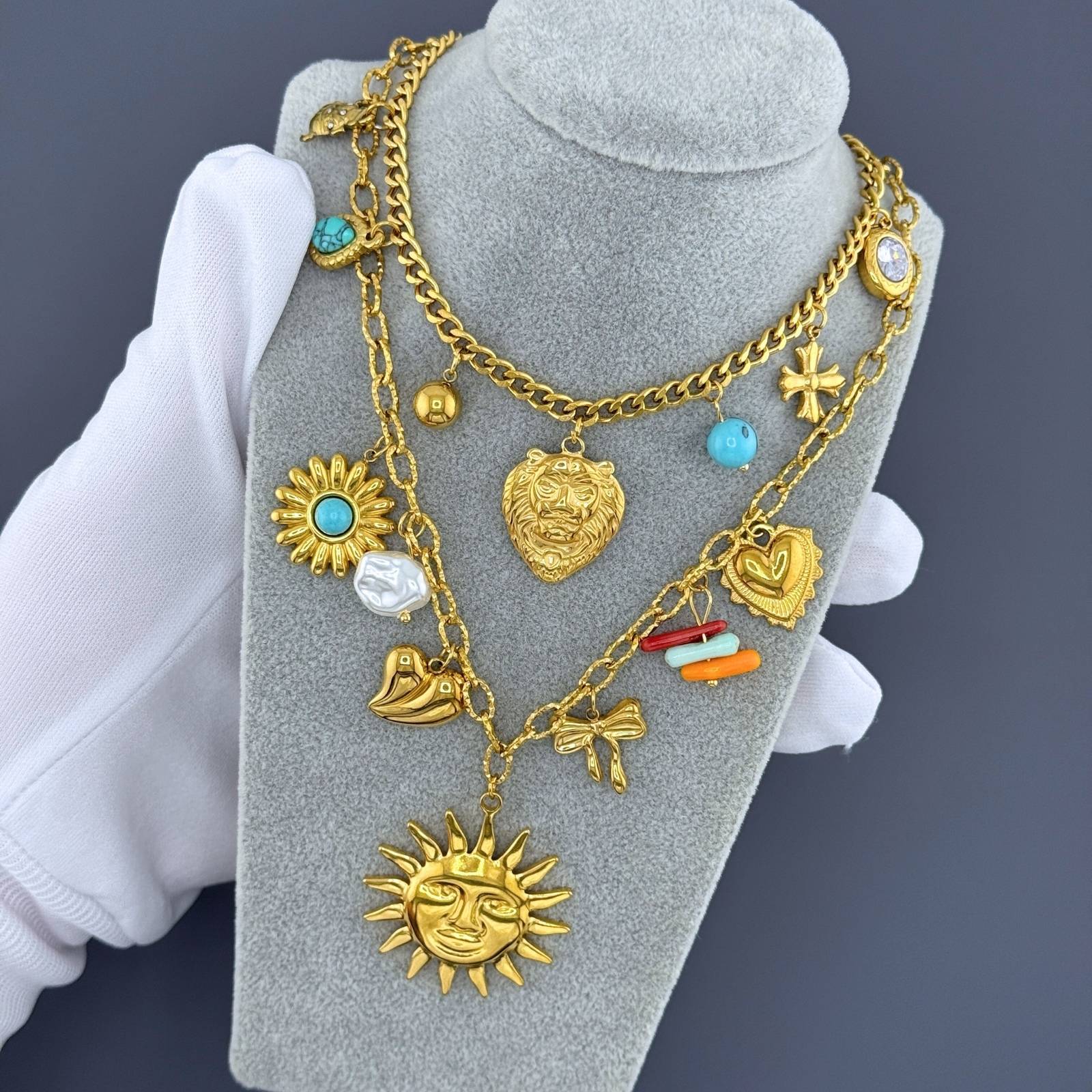 Layered Gold charm necklace featuring a sun face pendant, turquoise stone accents, pearl details, and celestial-inspired charms crafted from waterproof stainless steel.