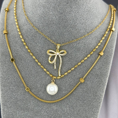 Layered Crystal bow pendant necklace in 18K gold-plated stainless steel with sparkling cubic zirconia stones.