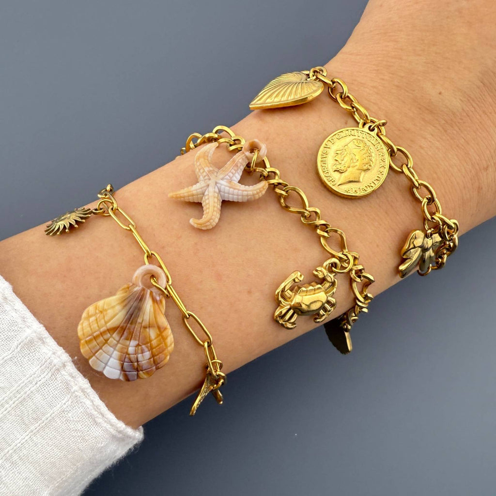 layered 18K gold plated stainless steel ocean charm bracelets. Featuring seashell, starfish, sea turtle, sunburst, and whale tail charms with adjustable chain.