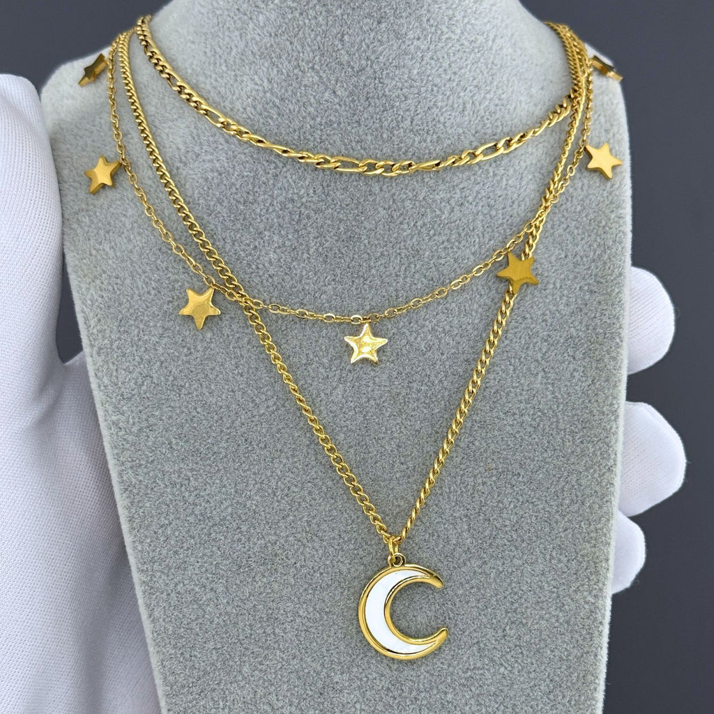 Layered gold necklace featuring a crescent moon pendant and star charms crafted from waterproof hypoallergenic stainless steel.