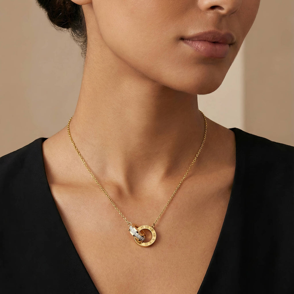 Interlocking circle necklace with Roman numeral detailing and cubic zirconia accents in 18K gold-plated stainless steel.