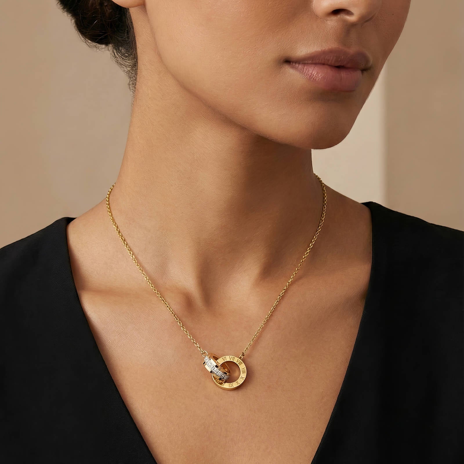 Interlocking circle necklace with Roman numeral detailing and cubic zirconia accents in 18K gold-plated stainless steel.