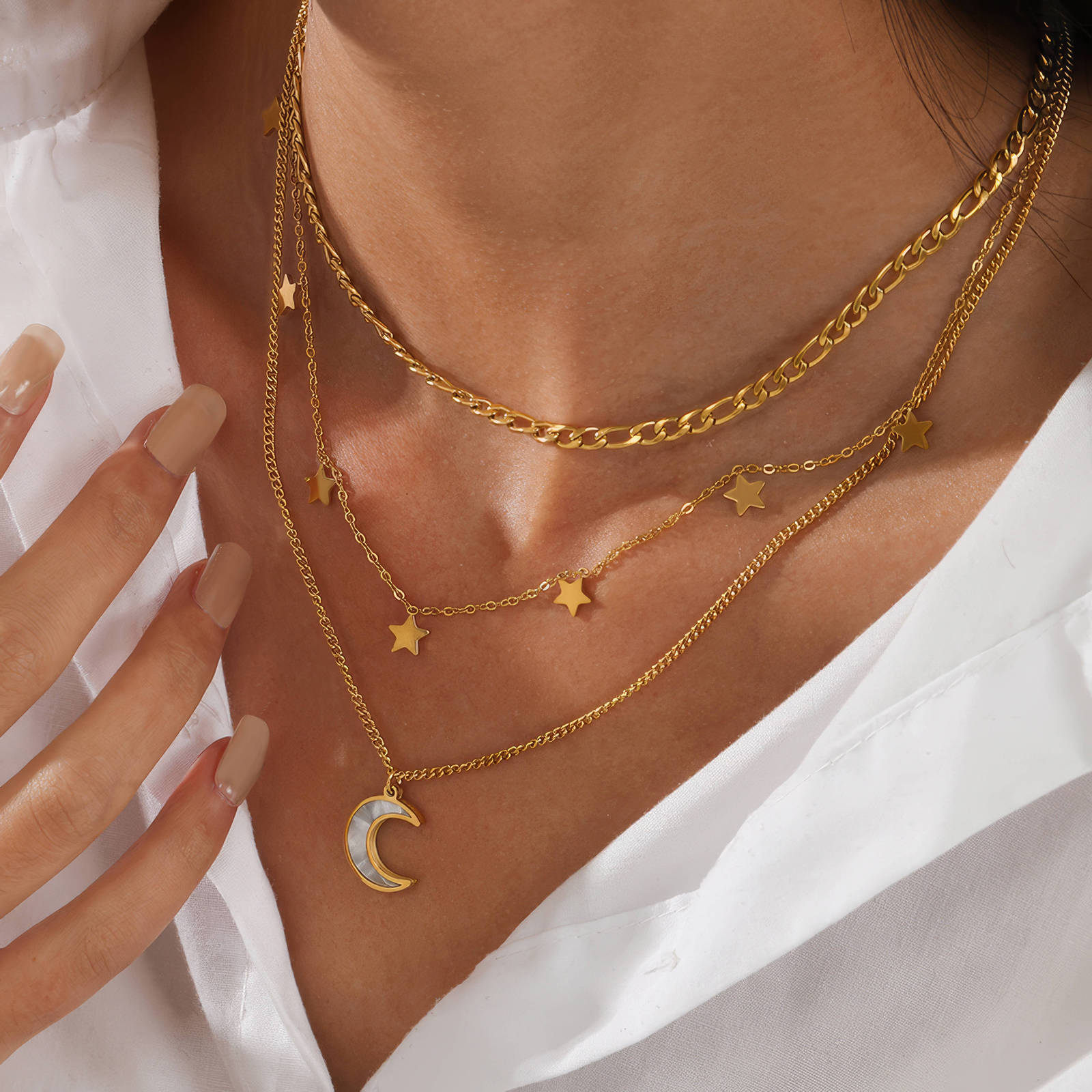 Layered gold necklace featuring a crescent moon pendant and star charms crafted from waterproof hypoallergenic stainless steel.