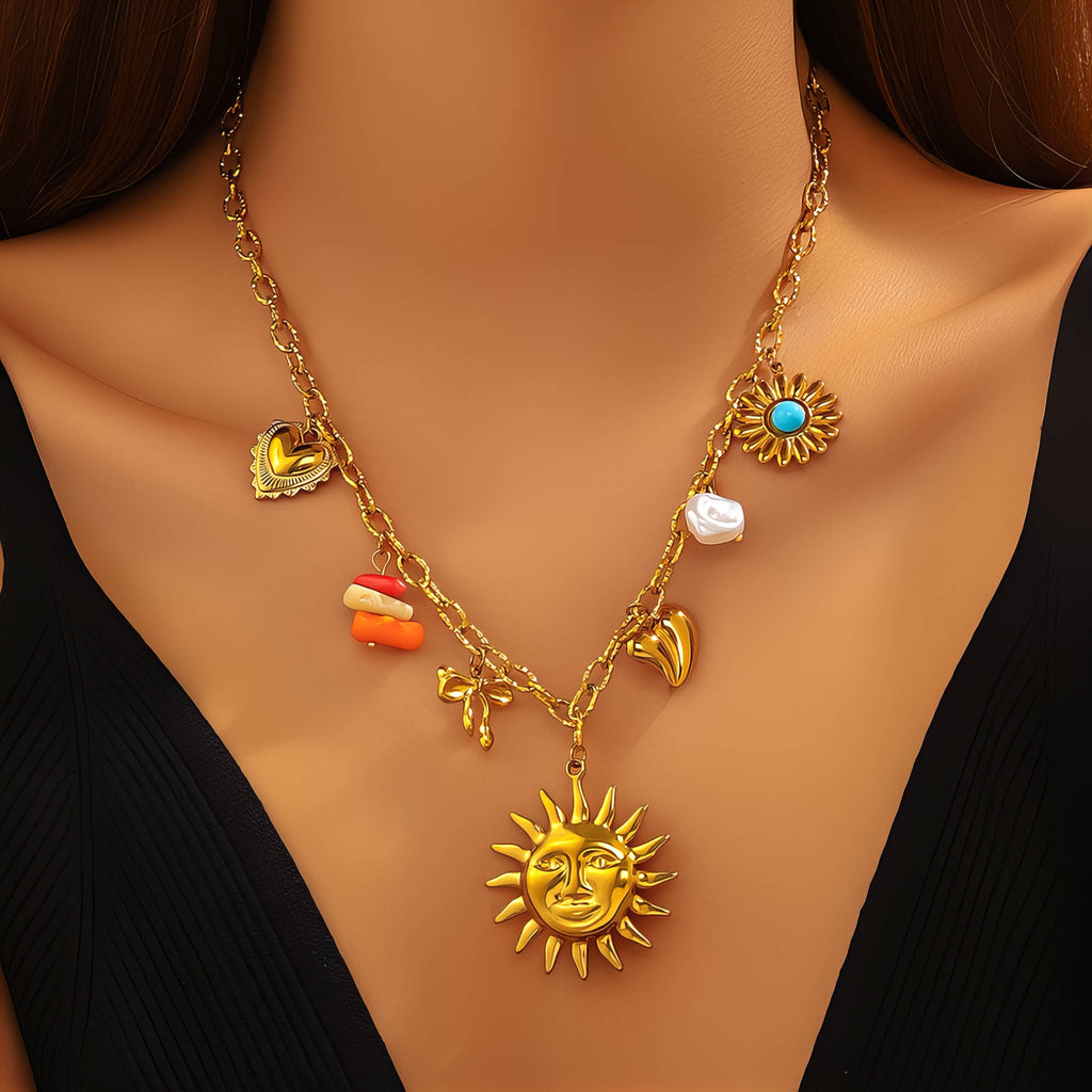 Gold charm necklace featuring a sun face pendant, turquoise stone accents, pearl details, and celestial-inspired charms crafted from waterproof stainless steel.