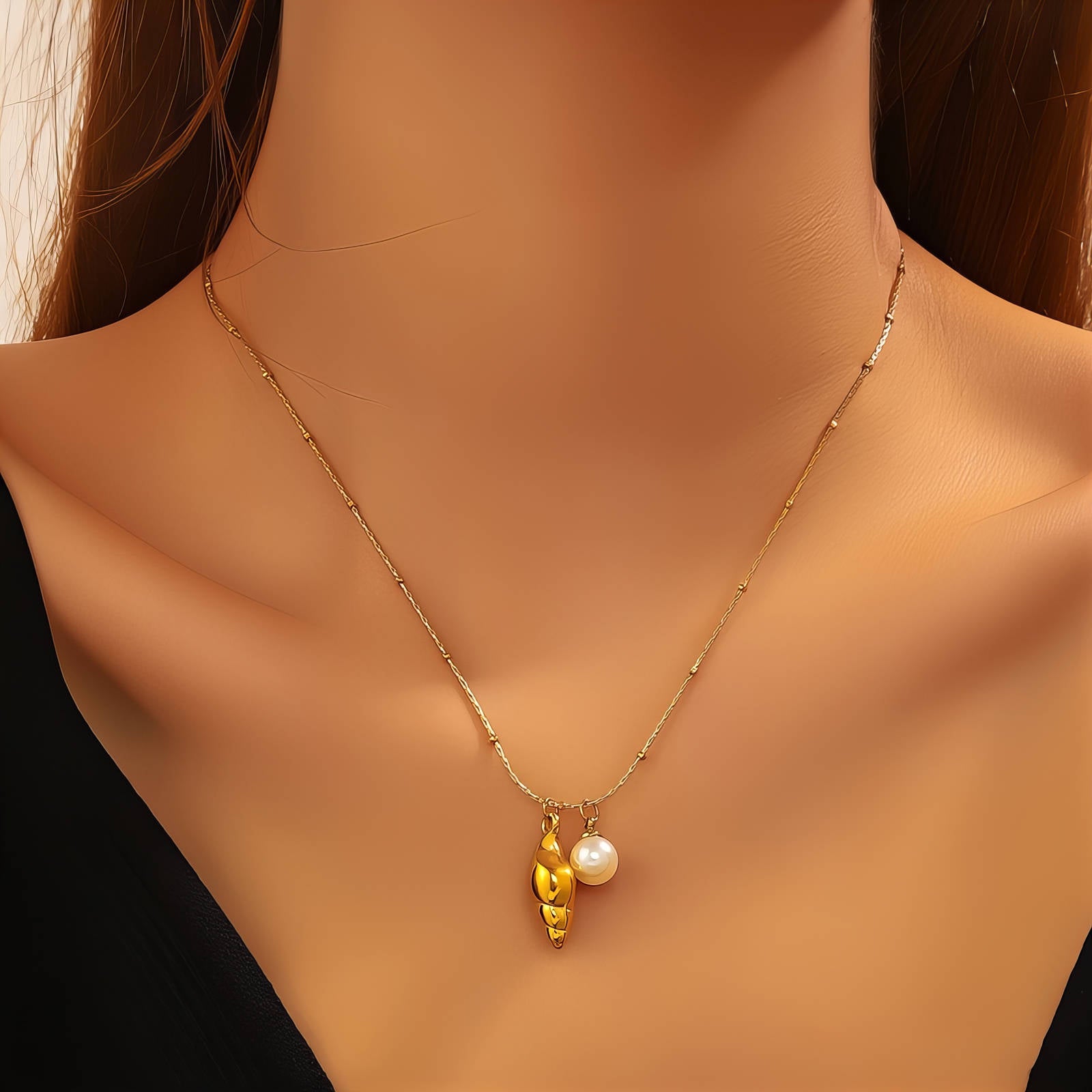 Gold seashell necklace with pearl accent crafted from waterproof hypoallergenic 18K gold-plated stainless steel.
