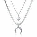 Layered silver stainless steel necklace featuring crescent moon and starburst celestial pendants with waterproof hypoallergenic design.