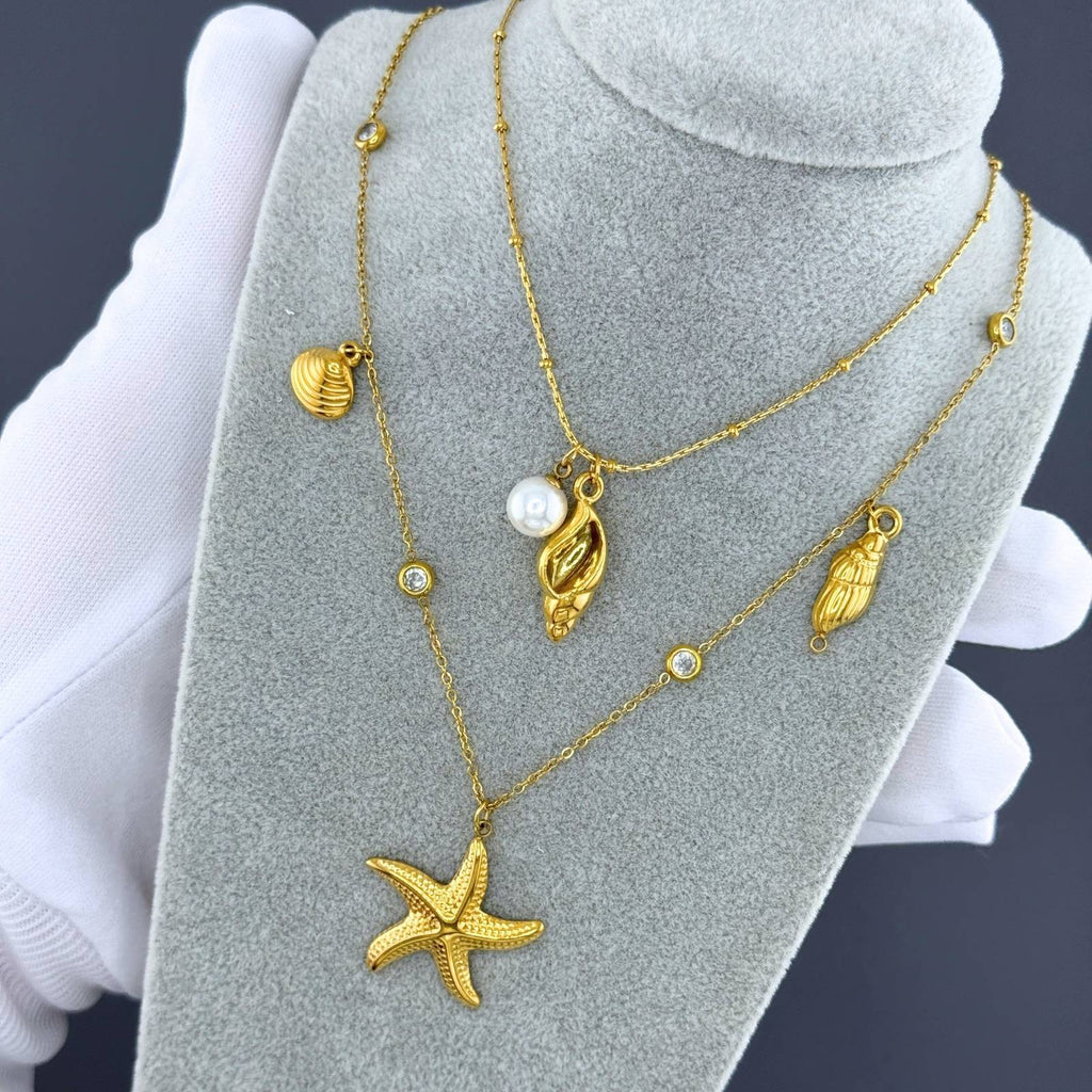 Layered Gold seashell necklace with pearl accent crafted from waterproof hypoallergenic 18K gold-plated stainless steel.