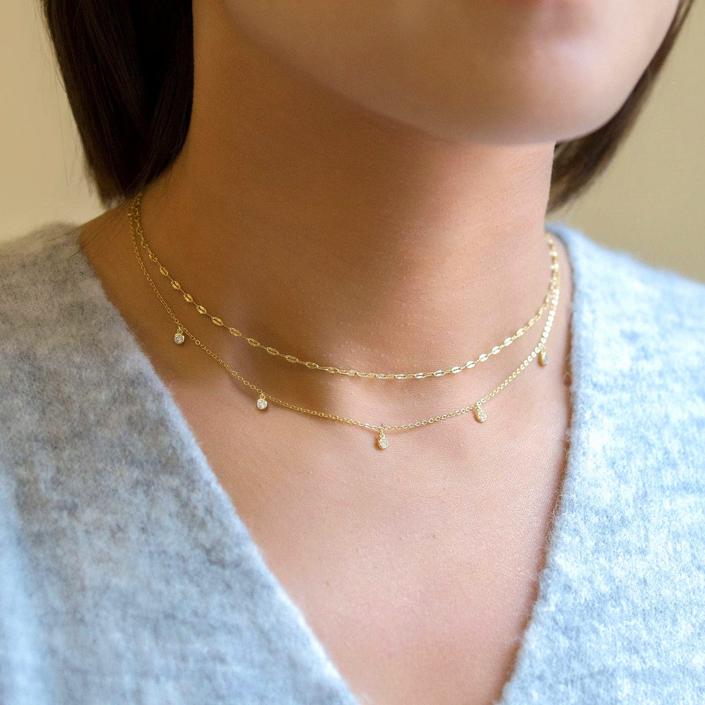 Layered gold necklace with delicate cubic zirconia charms in 18K gold-plated stainless steel.
